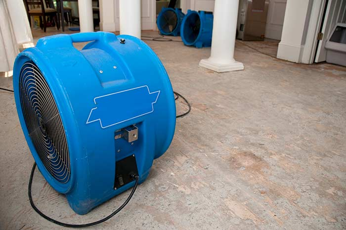 Air mover drying a water-damaged floor