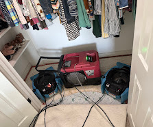 Dehumidifier and air movers drying a closet after water intrusion